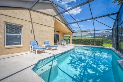 a swimming pool with two chairs and a house at Charming 3BR home in Kissimmee with private pool and lake view, perfect for families. in Kissimmee