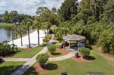 a park with a gazebo next to the water at Charming 3BR home in Kissimmee with private pool and lake view, perfect for families. in Kissimmee