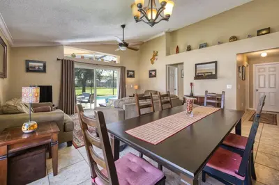 a dining room and living room with a table and chairs at Charming 3BR home in Kissimmee with private pool and lake view, perfect for families. in Kissimmee