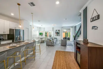 a kitchen and living room with a counter and chairs at Opulent Retreat Themed Bedrooms and Pool Paradise in Kissimmee