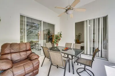 a living room with a couch and a table at Kissimmee Vacation Rental with Pool about 6 Mi to Disney in Kissimmee