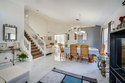 a dining room and living room with a table and chairs at Kissimmee Vacation Rental with Pool about 6 Mi to Disney in Kissimmee