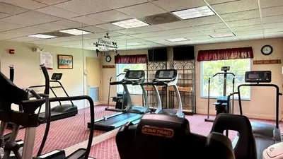 a gym with treadmills and ellipticals in a room at HSO - Family Apartments Close to Disney World & Universal in Orlando
