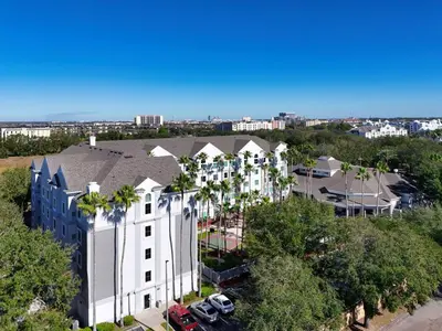 an aerial view of a white building with palm trees at HSO - Family Apartments Close to Disney World & Universal in Orlando