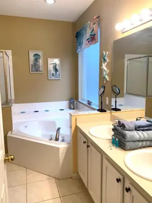 a large bathroom with a tub and two sinks at Complete Vacation in exclusive 7 Bed resort home, in Kissimmee