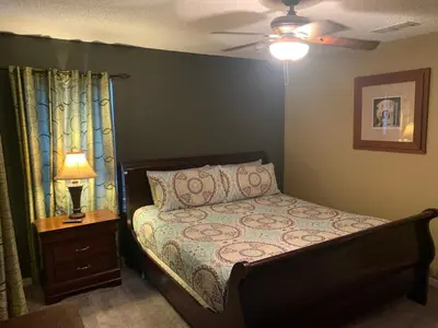 a bedroom with a bed and a lamp on a night stand at Complete Vacation in exclusive 7 Bed resort home, in Kissimmee
