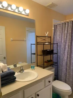 a bathroom with a sink and a toilet and a mirror at Complete Vacation in exclusive 7 Bed resort home, in Kissimmee