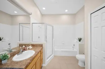 a white bathroom with a sink and a toilet at Caribe Cove Resort 3BR Condo Apt Disney Orlando in Kissimmee
