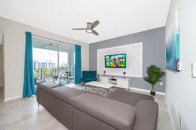 a living room with a couch and a tv at Beautiful Apartments 5 Minutes away from Disney! in Kissimmee
