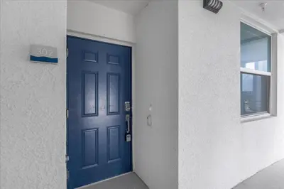 a blue door in a room with a window at Beautiful Apartments 5 Minutes away from Disney! in Kissimmee