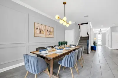 a dining room with a wooden table and blue chairs at Luxury Incredible Themed Home best vacation in Kissimmee