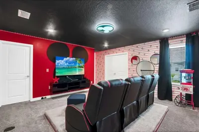 a cinema room with black chairs and a flat screen tv at Luxury Incredible Themed Home best vacation in Kissimmee