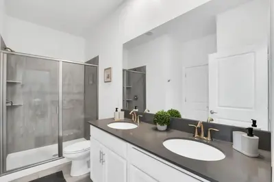 a bathroom with two sinks and a shower and a toilet at Luxury Incredible Themed Home best vacation in Kissimmee