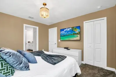 a bedroom with a white bed with blue pillows at Luxury Incredible Themed Home best vacation in Kissimmee