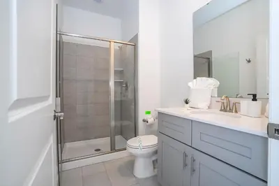 a bathroom with a shower and a toilet and a sink at Magnificient 4Bd w Pool @ Storey Lake Resort 2648 in Kissimmee