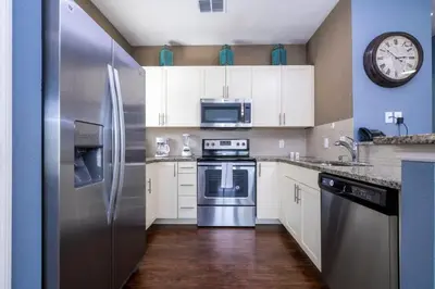 a kitchen with a stainless steel refrigerator and a clock at Marvelous 4 Bd Close To Disney at West Lucaya 8959 in Kissimmee