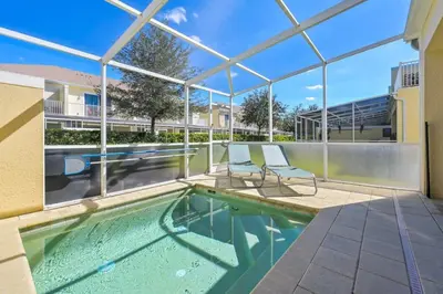 a swimming pool with two chairs next to a building at Charming Villa with Private Pool Bliss in Orlando
