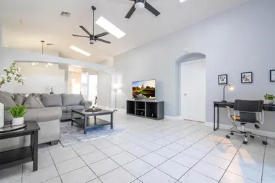 a living room with a couch and a table at Magical 5-Bedroom Retreat w/ Pool, 3 Ensuite Bedrooms, Near Disney, and Internet! in Kissimmee