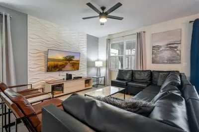 a living room with a couch and a ceiling fan at Family Paradise Space Themed Perfect Location in Kissimmee