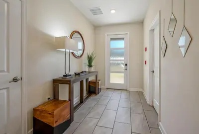 a hallway with a table and a mirror at Family Paradise Space Themed Perfect Location in Kissimmee