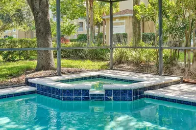 a swimming pool with blue tiles in a yard at Windsor Hills 4BR's Mickeys Ranch Near Disney in Orlando