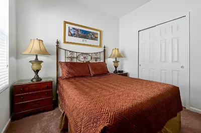 a bedroom with a bed and two lamps and a door at Windsor Hills 4BR's Mickeys Ranch Near Disney in Orlando