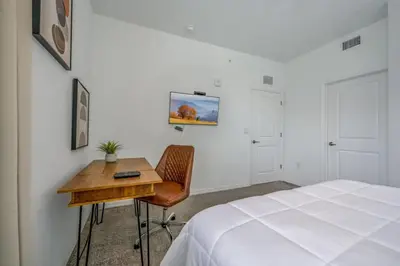 a bedroom with a bed and a desk next to a bed at Spacious Beautiful 3-BR Condo Prime Location in Kissimmee