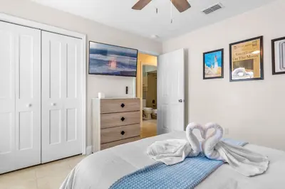 a bedroom with a bed with a towel on it at Beautiful Tropical Home with Private Heated and Chilled Pool in Kissimmee