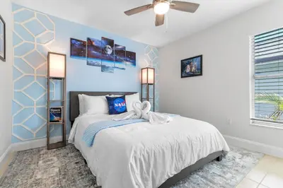 a bedroom with a bed and a ceiling fan at Beautiful Tropical Home with Private Heated and Chilled Pool in Kissimmee