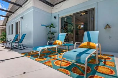 a group of chairs sitting on a patio at Beautiful Tropical Home with Private Heated and Chilled Pool in Kissimmee