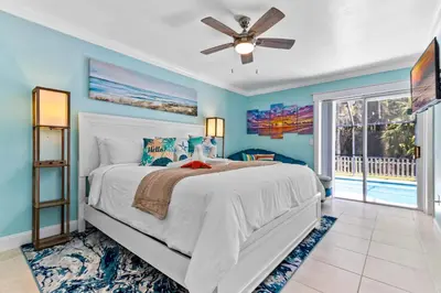 a bedroom with a bed and a ceiling fan at Beautiful Tropical Home with Private Heated and Chilled Pool in Kissimmee