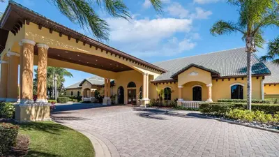 a large yellow house with a driveway at 8931 Cuban Palm in Kissimmee