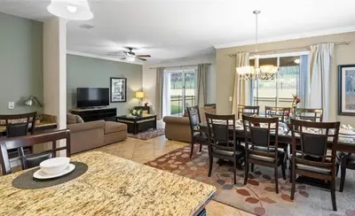 a living room with a table and a dining room at 8931 Cuban Palm in Kissimmee