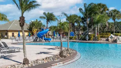 a pool at a resort with palm trees and a slide at 3071 Beach Palm in Kissimmee