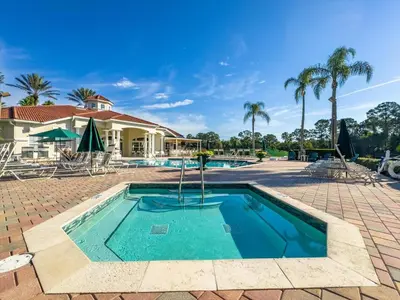 a swimming pool with palm trees and a house at 8538 Crystal Cove in Kissimmee