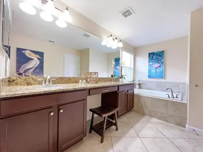a bathroom with a large sink and a tub and a stool at Banana Palm Paradise home in Kissimmee