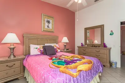 a bedroom with a large bed with a purple comforter at 2217 Wyndham Palms in Kissimmee