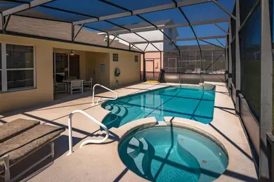 a large swimming pool on a patio with a house at 2217 Wyndham Palms in Kissimmee