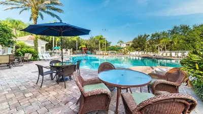 a patio with a table and chairs and a pool at 2217 Wyndham Palms in Kissimmee