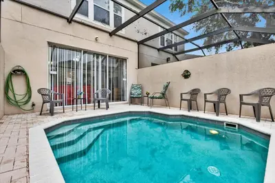a swimming pool with some chairs and a table at 2319 Silver Palm in Kissimmee