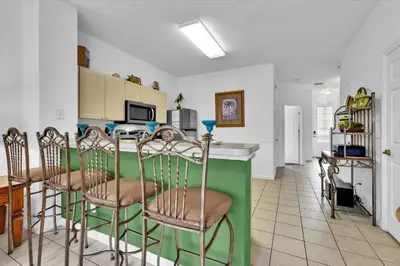 a kitchen with a green counter and some chairs at 2319 Silver Palm in Kissimmee