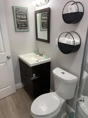 a bathroom with a toilet and a sink and a mirror at 1 BD Apt close to Disney/Universal/Shopping/Dining in Kissimmee