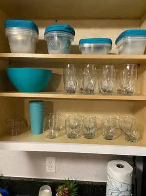 a shelf filled with glasses and blue bowls at 1 BD Apt close to Disney/Universal/Shopping/Dining in Kissimmee