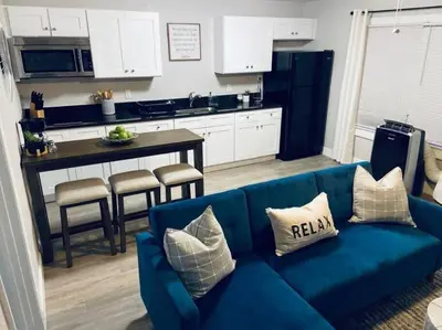 a living room with a blue couch and a kitchen at 1 BD Apt close to Disney/Universal/Shopping/Dining in Kissimmee