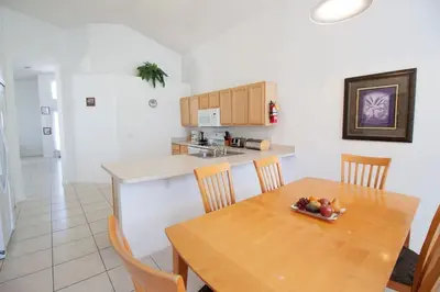 a kitchen and dining room with a wooden table and chairs at Private Pool Home at Seasons Community in Kissimmee