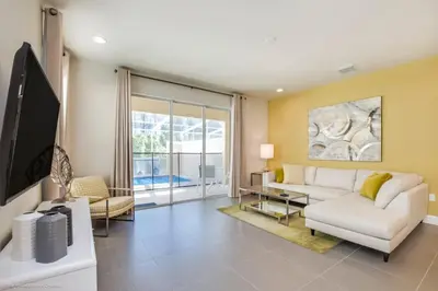 a living room with a white couch and a tv at Luxury Retreat with Pool in Orlando