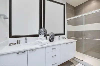 a white bathroom with a sink and a shower at Luxury Retreat with Pool in Orlando