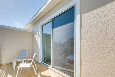 a room with a large window and a chair on a balcony at Luxury Retreat with Pool in Orlando