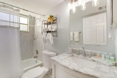 a white bathroom with a toilet and a sink at Kissimmee Condo with Perks 6 Mi to Disney World! in Kissimmee