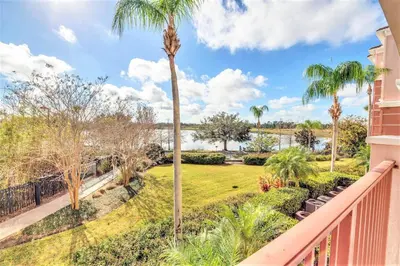 a balcony with palm trees and a park at Lake Front Huge by clubhouse in Orlando